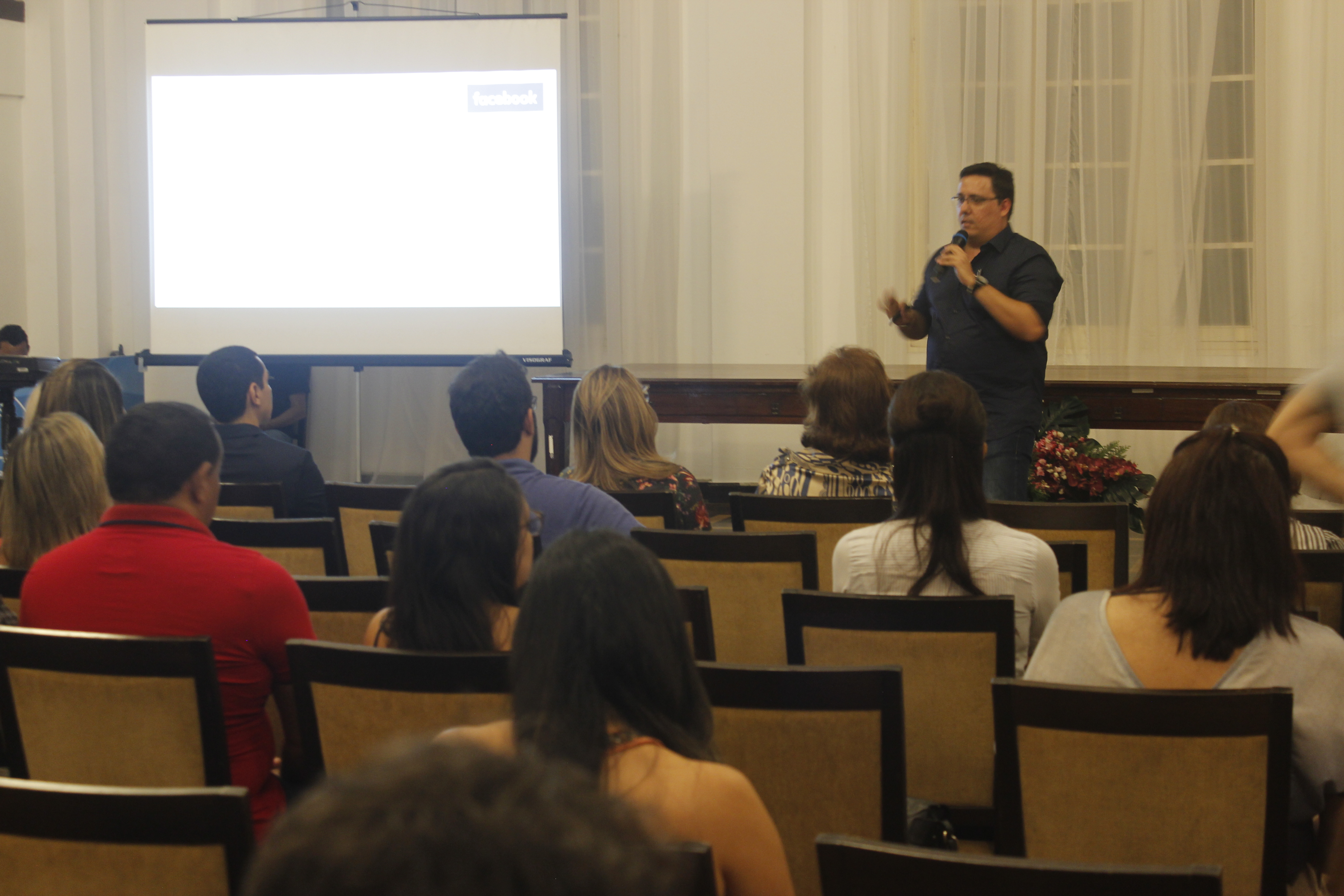 Reinaldo Valente palestrando para plateia em auditório